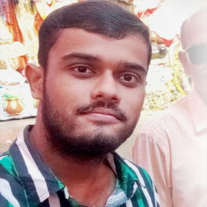 My portrait;A early 20s male with noticeable short hair, light facial hair wearing a red tee at a roadside gathering